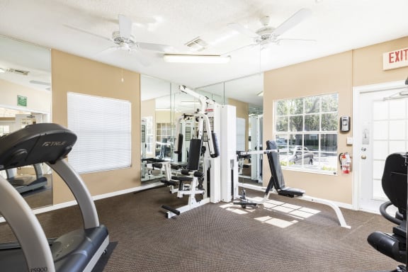 Fitness center facing workout machines and mirrors