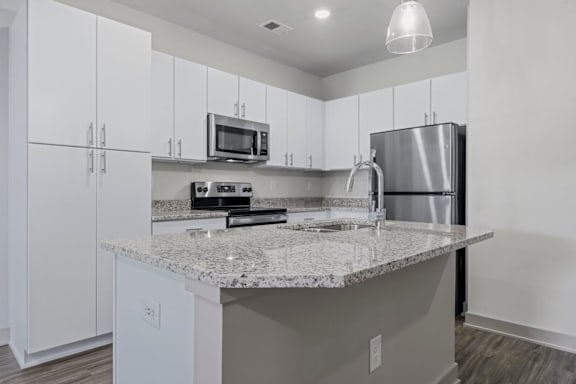 A kitchen with a granite countertop and stainless steel appliances at Litchford 315 Apartments, Raleigh, North Carolina