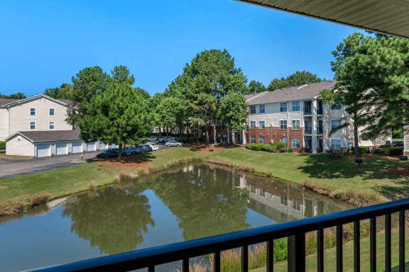 Patio with View of Pond with Building Exteriors  and Trees in the Background