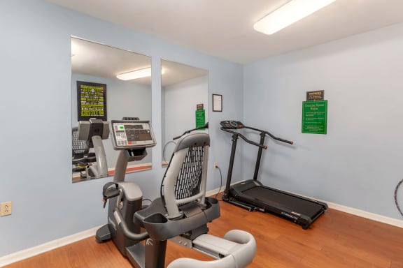 Fitness Center with Exercise Equipment and Mirror Accents on Wall