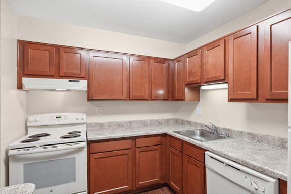 A kitchen with brown cabinets and a white stove.