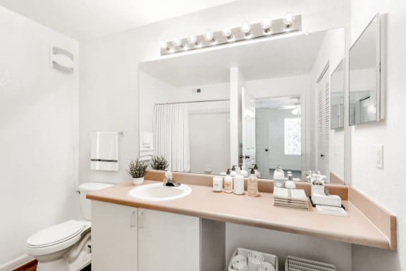 Virtually staged bathroom with large mirror, toilet, medicine cabinet
