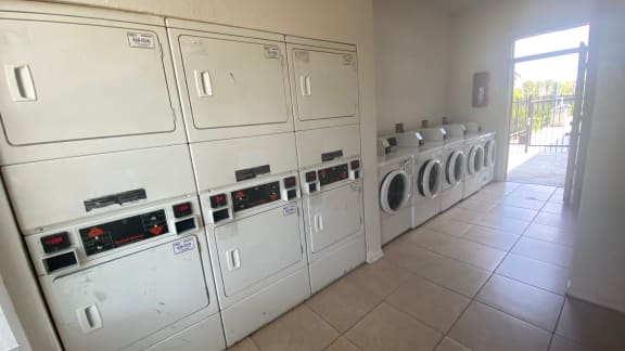 Laundry center with washers and dryers and tile flooring