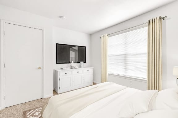Bedroom with large window dresser with a tv