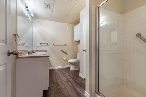 bathroom with hard wood floors and glass shower door