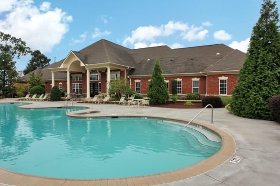 Swimming pool with tanning deck and clubhouse exterior in the background