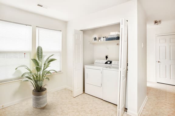 Virtually staged Laundry room with large windows and tile floor.