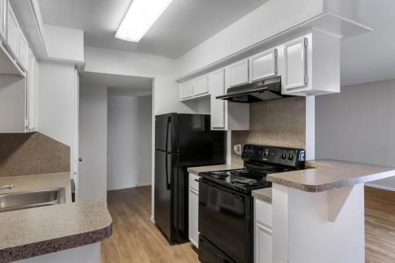 Kitchen with White Cabinets Grey Counters and Black Appliances