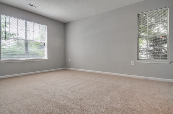 Empty bedroom with carpet and two windows