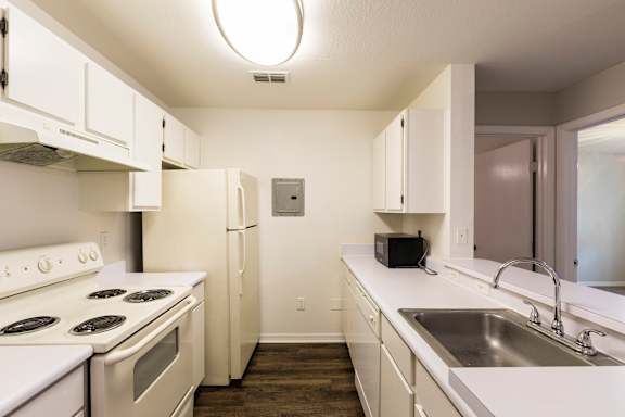 A kitchen with white appliances and cabinets.