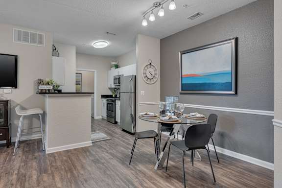 A modern kitchen with a dining table set for two.