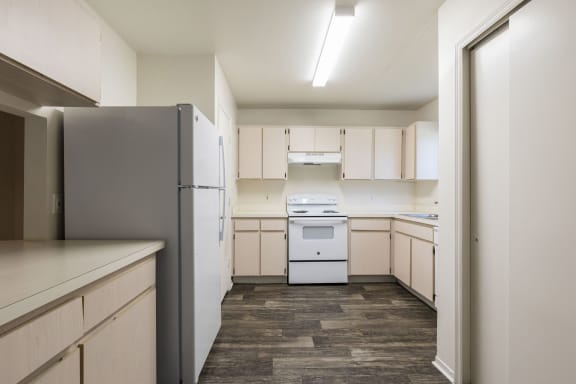 cream colored cabinets with white appliances and hardwood style flooring