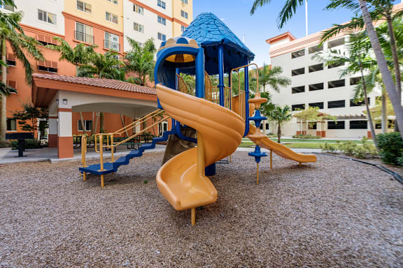 A playground with a blue roofed slide and a yellow slide.