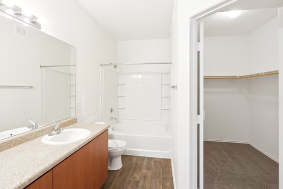 Bathroom with tub shower combo and walk-in closet at Lake Pleasant Village Apartments, Arizona, 85382