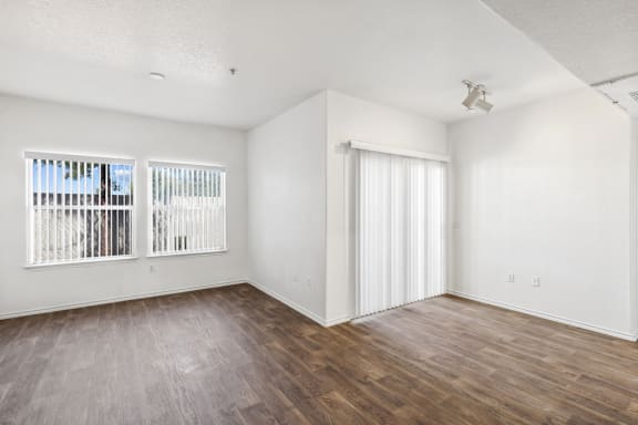 Unfurnished room with wood flooring and white vertical blinds at Lake Pleasant Village Apartments, Peoria, AZ