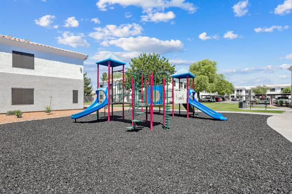 Colorful playground with slides and climbing equipment at Lake Pleasant Village Apartments, Arizona
