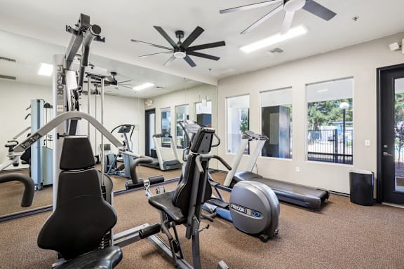 Fitness center with weight machines and elliptical trainer at Lake Pleasant Village Apartments, Peoria, AZ 85382