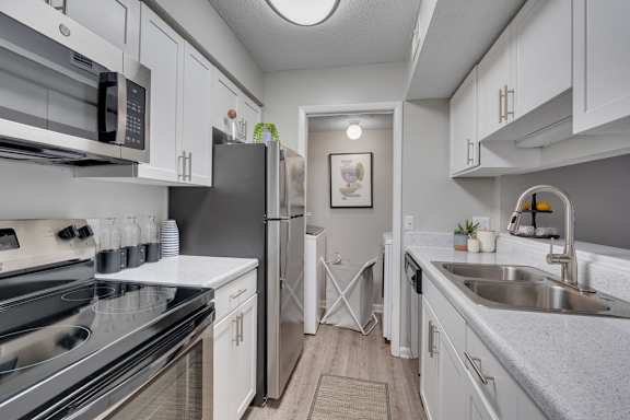 A modern kitchen with stainless steel appliances and white cabinets.