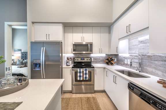 a kitchen with white cabinets and stainless steel appliances