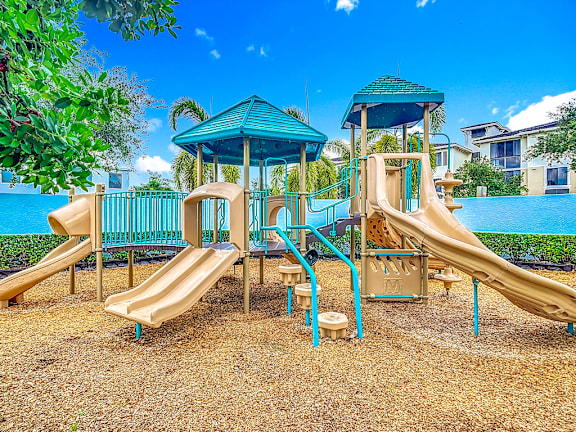 A playground with a blue slide and a green roofed structure.