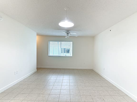 Empty room with a ceiling fan and a window.