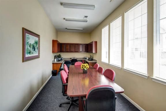Business Center with Conference Table Maroon Chairs and Computers and Wood Cabinets
