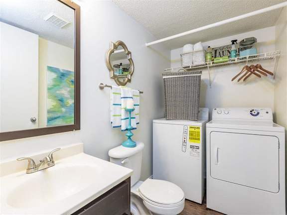 Model Bathroom with Washer and Dryer Below Wire Shelf with Decorations and Supplier at Regency Park Apartment Homes, Raleigh, 27616