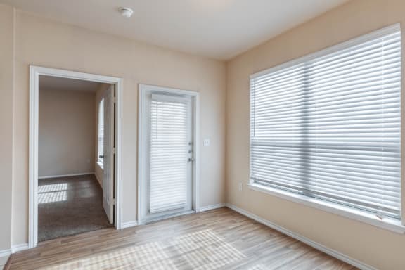 a living room with two large windows and a door to the patio