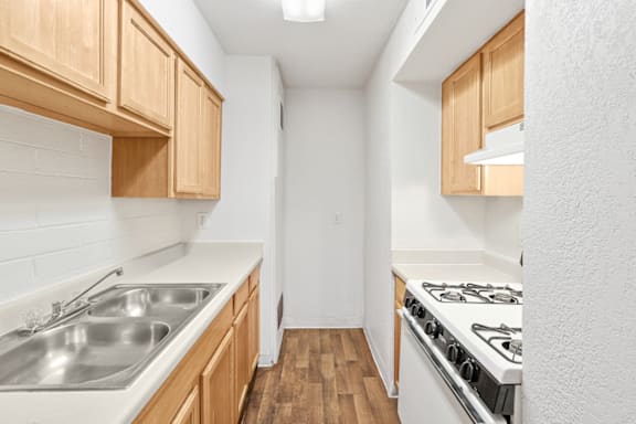 a kitchen with white countertops and wood cabinets
