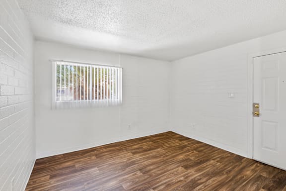 a bedroom with hardwood floors and a window
