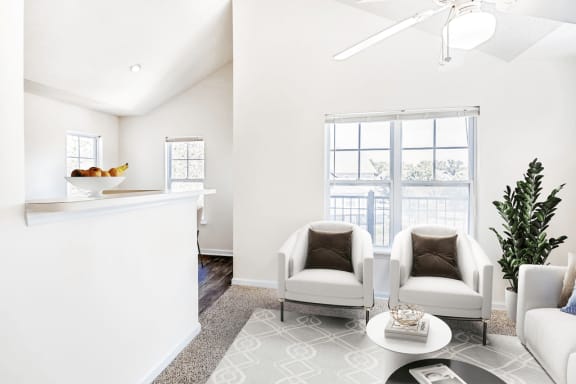 Virtually staged; Carpeted 3rd Floor Living Room with Vaulted Ceilings with White Ceiling Fan Large Window and Breakfast Bar with two grey accent chairs and green potted plant