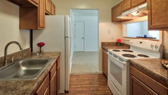 Model Kitchen with Wood Cabinets, Brown Counters, White Appliances and Decorations