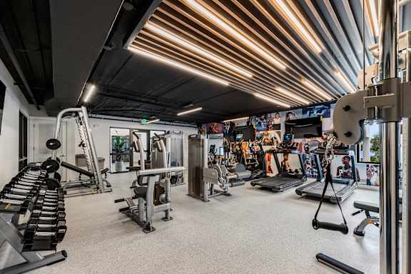 a gym with weights and other exercise equipment and a ceiling with lights