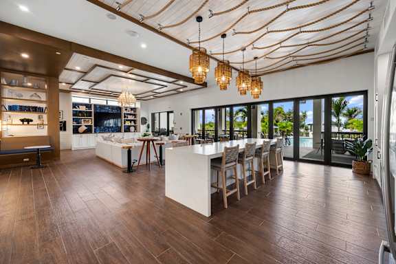 the home has a large entertaining area with a bar and glass doors to the pool