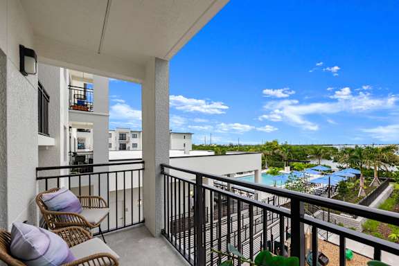 a balcony with two chairs and a view of a body of water
