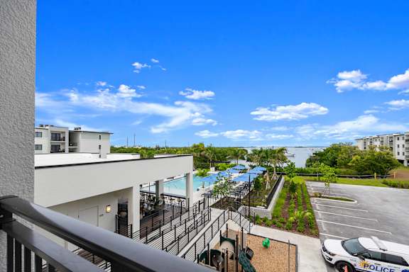 a view of the pool from the balcony of a building with a blue sky