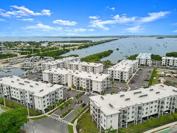 an aerial view of apartment buildings next to a body of water
