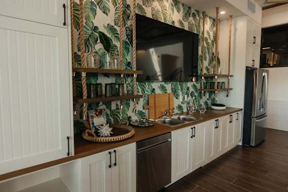 a kitchen with white cabinets and a sink and a mirror