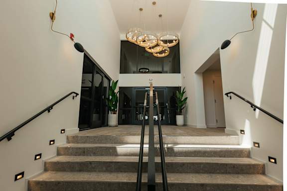 a view of a lobby with stairs and a chandelier