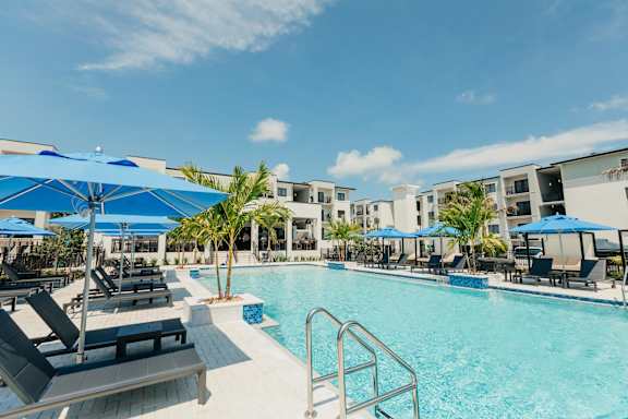 a swimming pool with lounge chairs and umbrellas at the resort