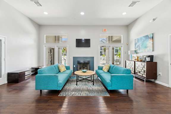 A living room with a blue couch and a fireplace.