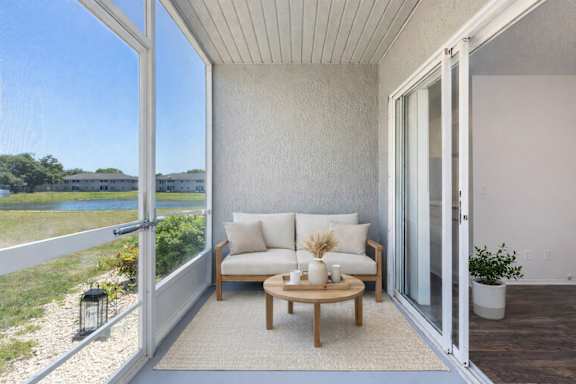 a screened-in patio with a chair and table