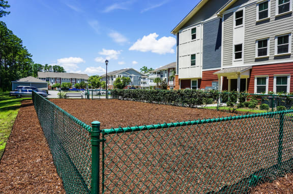 apartments with a playground and a chain link fence