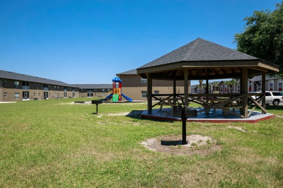 Gazebo in the courtyard with building exteriors and playground in the background