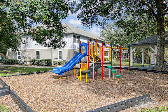 A playground with a blue slide and red and yellow play structures.