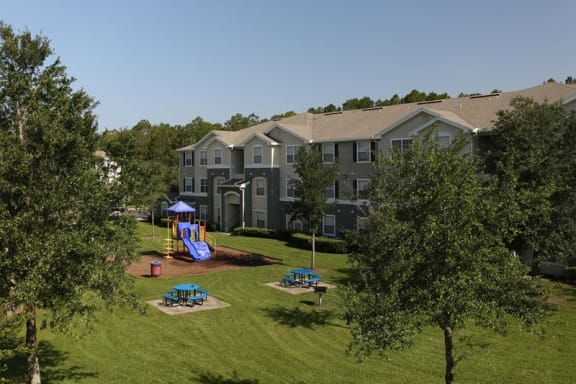 Outdoor Playground equipped with a slide, monkey bars, latter, and picnic tables