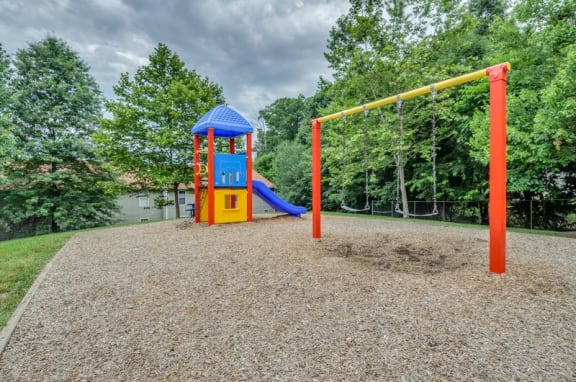 Playground on wood clips surrounded by building exteriors and trees