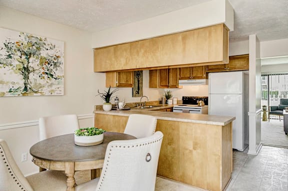 A kitchen with a table and chairs in front of it.at Patriot Point Apartment Homes, Spring Lake