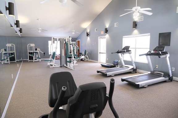 A gym with treadmills, elliptical machines, and other exercise equipment.