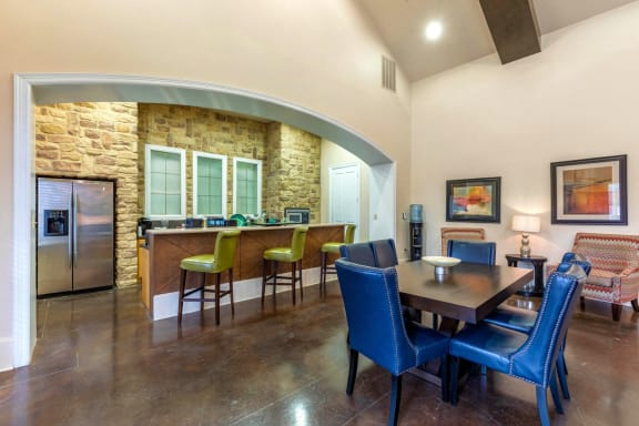 CLubhouse Dining Table Next to Clubhouse Kitchen with Bar and Brick Wall